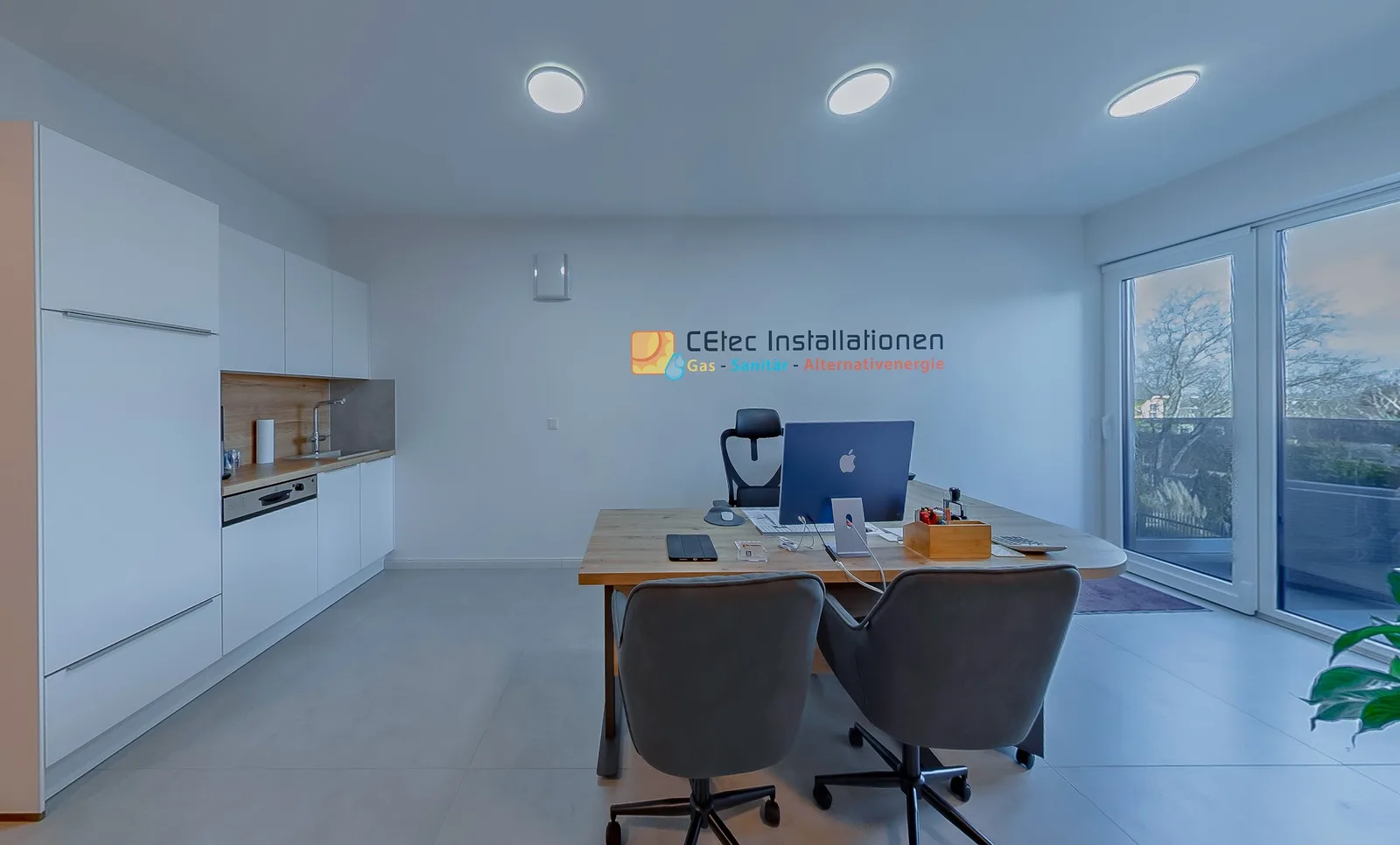 Heller Besprechungsraum mit Schreibtisch, zwei Stühlen und dem CEtec-Logo an der Wand
